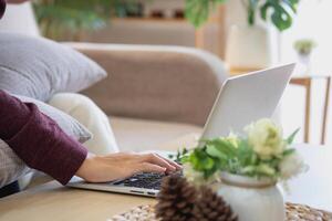 Relaxed young Asian woman enjoying relaxation on a comfy sofa at home. The beautiful girl calmly relaxes and breathes fresh air in the house. Watch movies and social networks. photo