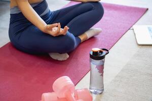 Healthy young woman doing breathing exercises at home, beautiful woman meditating at home with eyes closed, practicing yoga, doing pranayama techniques Mindfulness meditation concept photo