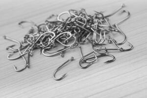 Close up, Pile of fish hooks on wooden background photo