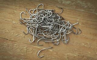 Close up, Pile of fish hooks on wooden plank background photo