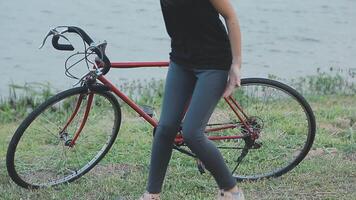 contento giovane asiatico donna mentre equitazione un' bicicletta nel un' città parco. lei sorrise utilizzando il bicicletta di trasporto. l'ambiente amichevole concetto. video