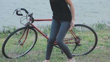 contento joven asiático mujer mientras montando un bicicleta en un ciudad parque. ella sonrió utilizando el bicicleta de transporte. ambientalmente simpático concepto. video