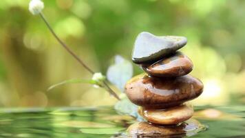 relajante equilibrado rocas pirámide en agua con dorado ligero natural paz conceptos bokeh en antecedentes video