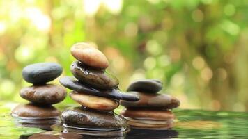 Three wellness Balanced rocks pyramid on water with Golden light natural peace concepts bokeh on background video