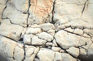 Texture of mountain rock on a sunny day, background. Lines and spots. Antibes, France photo