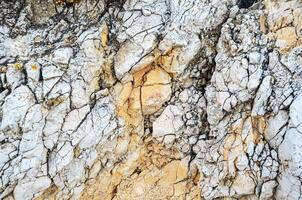 Texture of mountain rock on a sunny day, background. Lines and spots. Antibes, France photo