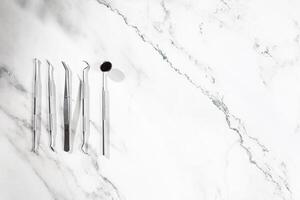 Dental instrument and flat layer on marble background photo