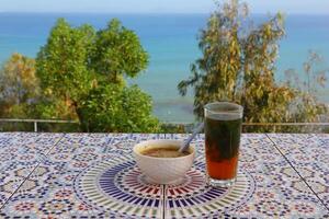 A cup of Moroccan tea with a view of the sea from in Tangier photo