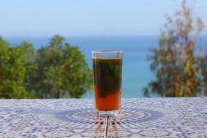 A cup of Moroccan tea with a view of the sea from in Tangier photo