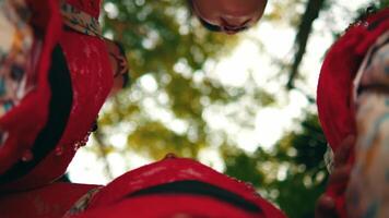 Close-up of a person's hands holding each other, with autumn leaves in the soft-focus background. video