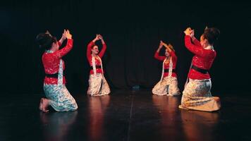 Traditional dancers in colorful costumes performing on stage with expressive poses and movements. video