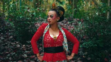 Woman in traditional attire standing in a forest with autumn leaves. video