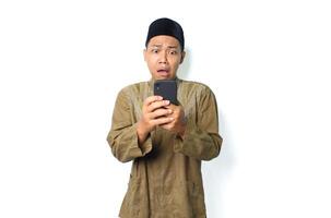 shocked asian muslim man holding mobile phone isolated on white background photo