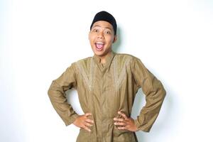 shocked asian muslim man looking at camera with hands on waist isolated on white background photo