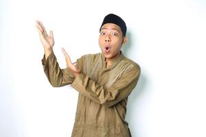 surprised asian muslim man presenting to the right side with open palm isolated on white background photo