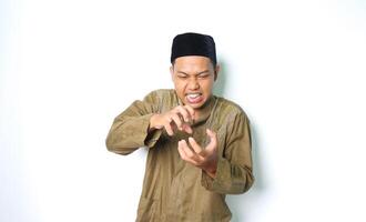 angry asian muslim male screaming with grabbing hand isolated on white background photo