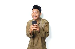 funny asian muslim man using smartphone looking at camera show grin smile isolated on white background photo