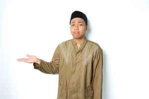 asian muslim man presenting to beside with stressed expression isolated on white background photo