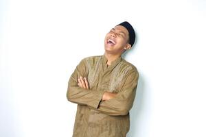 ecstatic asian muslim man laughing with folded arms wearing islamic dress isolated on white background photo