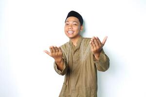 happy asian muslim man wearing koko clothes presenting at camera with open palms isolated on white background photo