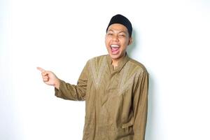excited asian moslem man screaming with pointing to the right side wearing islamic dress isolated on white background photo