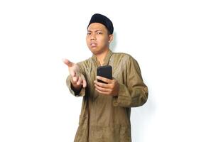 confused asian muslim man holding mobile phone offering handshake isolated on white background photo