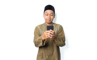 pleased asian muslim man read a message using mobile phone isolated on white background photo