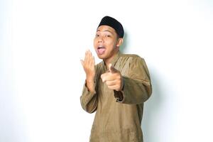 shocked asian muslim man pointing at camera with covering open mouth isolated on white background photo