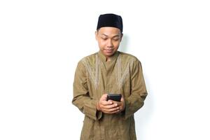 pleased asian muslim man read a message using mobile phone isolated on white background photo