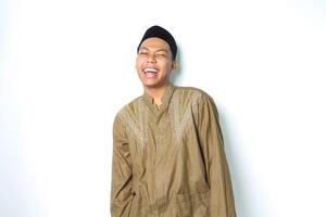 laughing asian moslem man wearing koko clothes standing over isolated white background photo