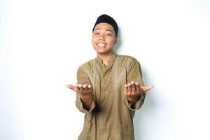 happy asian muslim man wearing koko clothes presenting at camera with open palms isolated on white background photo