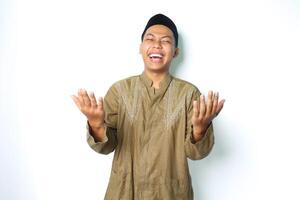 alegre asiático musulmán hombre riendo mientras Orando aislado en blanco antecedentes foto