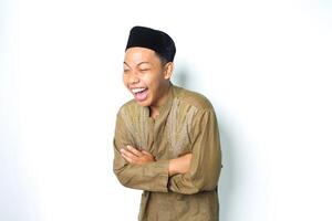 ecstatic asian muslim man laughing with folded arms wearing islamic dress isolated on white background photo