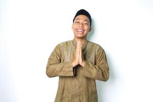 asian muslim man give greeting with laugh in eid mubarak celebration isolated on white background photo