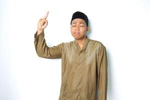 sad asian moslem man pointing to above isolated on white background photo