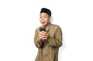 funny asian muslim man using smartphone looking at camera show grin smile isolated on white background photo