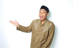 surprised asian muslim man presenting to beside isolated in white background photo