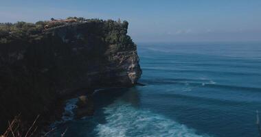 balinesisch Tempel auf felsig Cliff und Ozean mit Wellen im Bali. szenisch und Beliebt Reise Ziel video