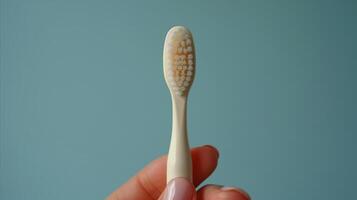 AI generated Worn out toothbrush held in hand with blue background photo