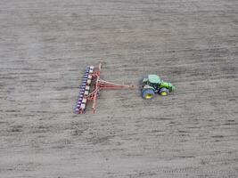 Sowing of corn. Tractor with a seeder on the field. Using a seeder for planting corn. photo