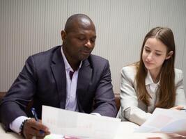 sur África negro piel calvo vestir traje blanco uniforme hembra mujer de negocios empresario trabajo trabajo interior oficina papel Nota comienzo arriba persona de negocios juntos americano profesor estudiante moderno diálogo foto