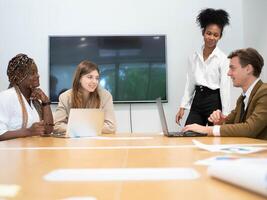 trabajo en equipo grupo negocio empresario mujer de negocios hembra masculino dama Caballero hablando hablar cuaderno computadora presentación reunión persona de negocios corporativo entrenamiento salón de clases diversidad gerente profesor foto