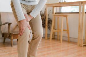 man suffering from pain in knee at home, closeup , healthcare concept photo