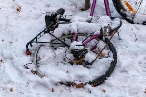 un caído bicicleta en invierno en el nieve foto