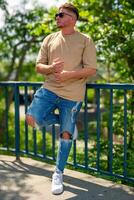 an attractive young man in a city park in summer photo