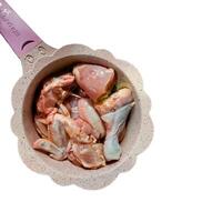 pieces of fresh chicken meat in a pink pot photo