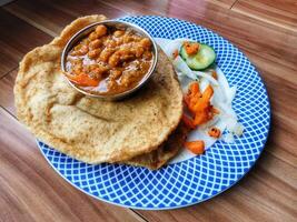 Healthy Chole Bhature tasty Indian dish made using wheat flour is arranged in a porcelain plate photo