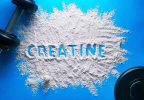 dispersado polvo con el palabra creatina escrito en eso en un azul antecedentes. foto