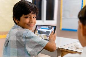 retrato de elemental Hispano colegio niños utilizando tableta ordenadores en clase foto