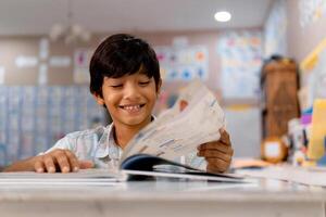 retrato de elemental chico leyendo un libro en un clase. foto